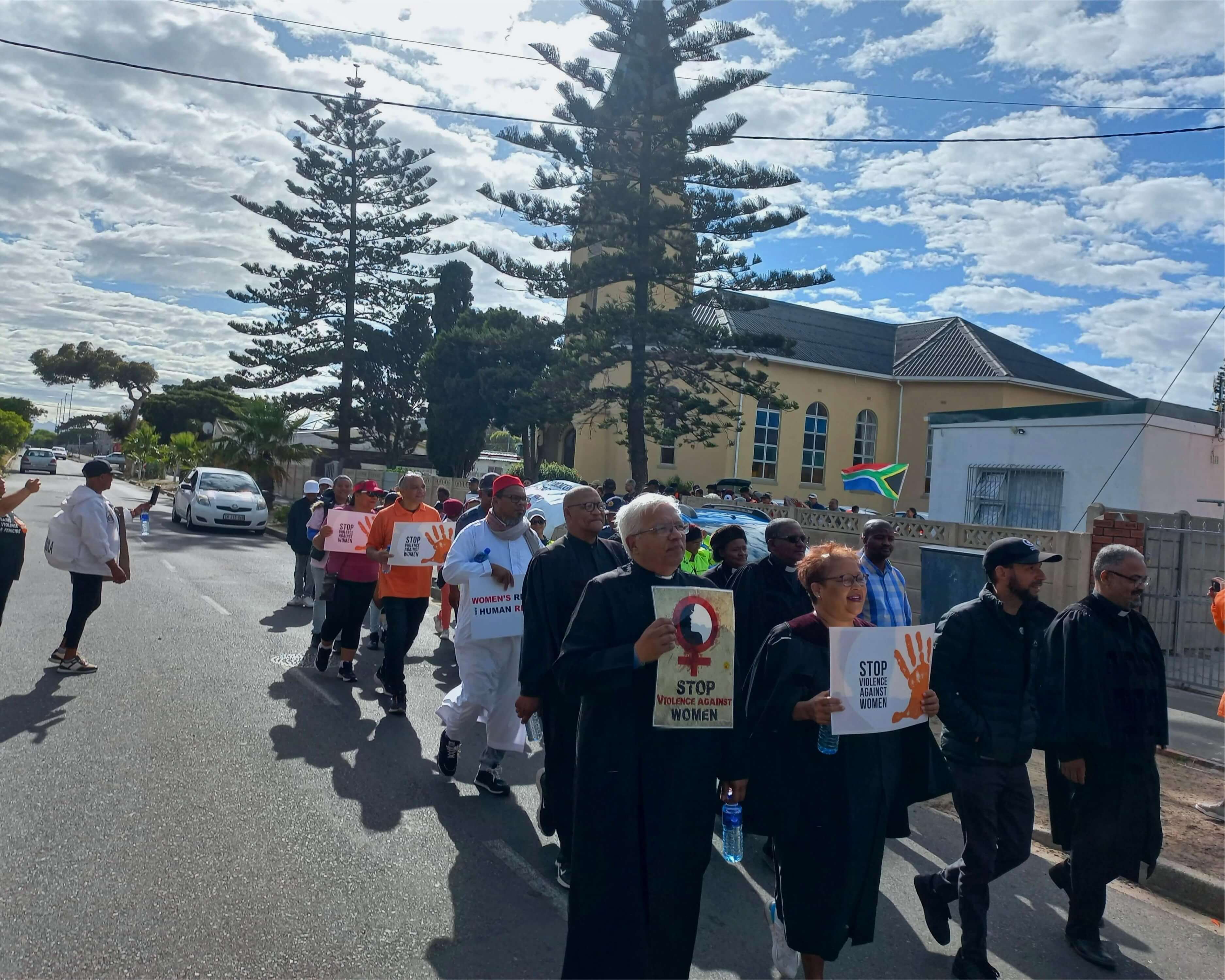 A group of men and women walking with GBV posters